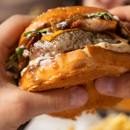 Delicioso hambúrguer bovino de 120g com generosas fatias de queijo prato, bacon, azeitona e requeijão