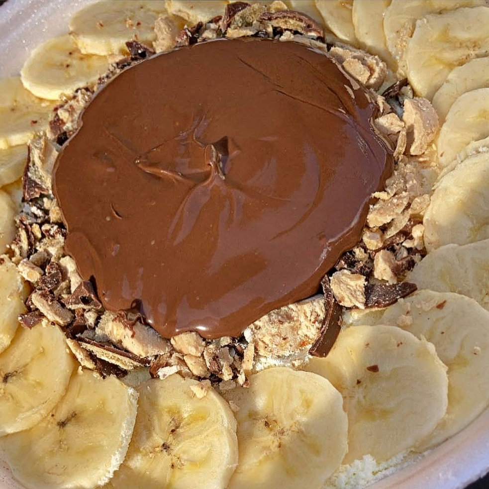 Açai no isopor de 1 litro com uma camada de leite em pó ninho, bananas fatiadas, 1 bombom ouro branco picado e nutella original.