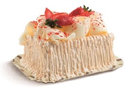 Bolo branco, recheio de cocada e mousse branca com morangos, cobertura de mousse branca, raspas de chocolate branco, calda de morango e morangos.