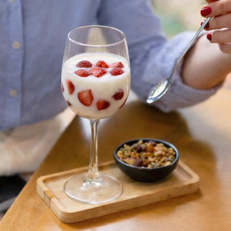 Pedaços de morango mergulhados em iogurte sem açúcar sem lactose com nossa granola da Ka para arrematar.