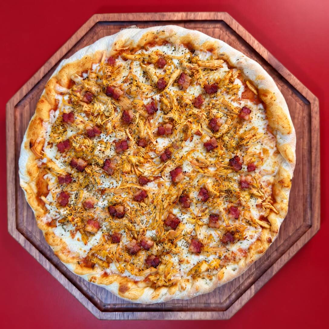 Massa especial, molho de tomate, mussarela, frango desfiado e bacon, preparada com ingredientes selecionados para garantir muito sabor em cada pedaço.
