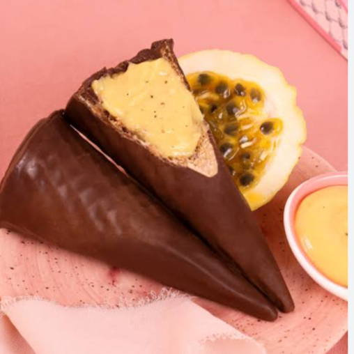 Casquinha coberta de chocolate e recheado de brigadeiro de maracujá