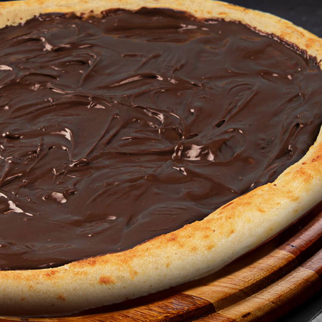 Para os amantes de chocolate! Creme de leite com generosas porções de chocolate ao leite derretido sobre uma massa de pizza macia e fofa. Simplesmente irresistível!