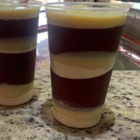 Uma deliciosa Vitamina de açaí Cremoso Acompanhado de Leite Condensado Integral em Camadas.