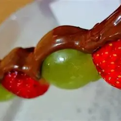 Delicioso espetinho de morango com uvas coberto com chocolate