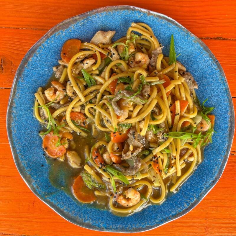 Yakisoba com frango, carne e legumes frescos salteados no molho oriental. Sabor e tradição em cada garfada! (Aprox. 750g)