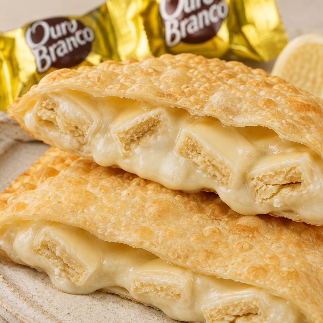 Uma explosão de cremosidade que conquista na primeira mordida! Nosso pastel de bombom ouro branco é com irresistível chocolate branco e pedacinhos crocantes que derretem na boca e despertam todos os sentidos.