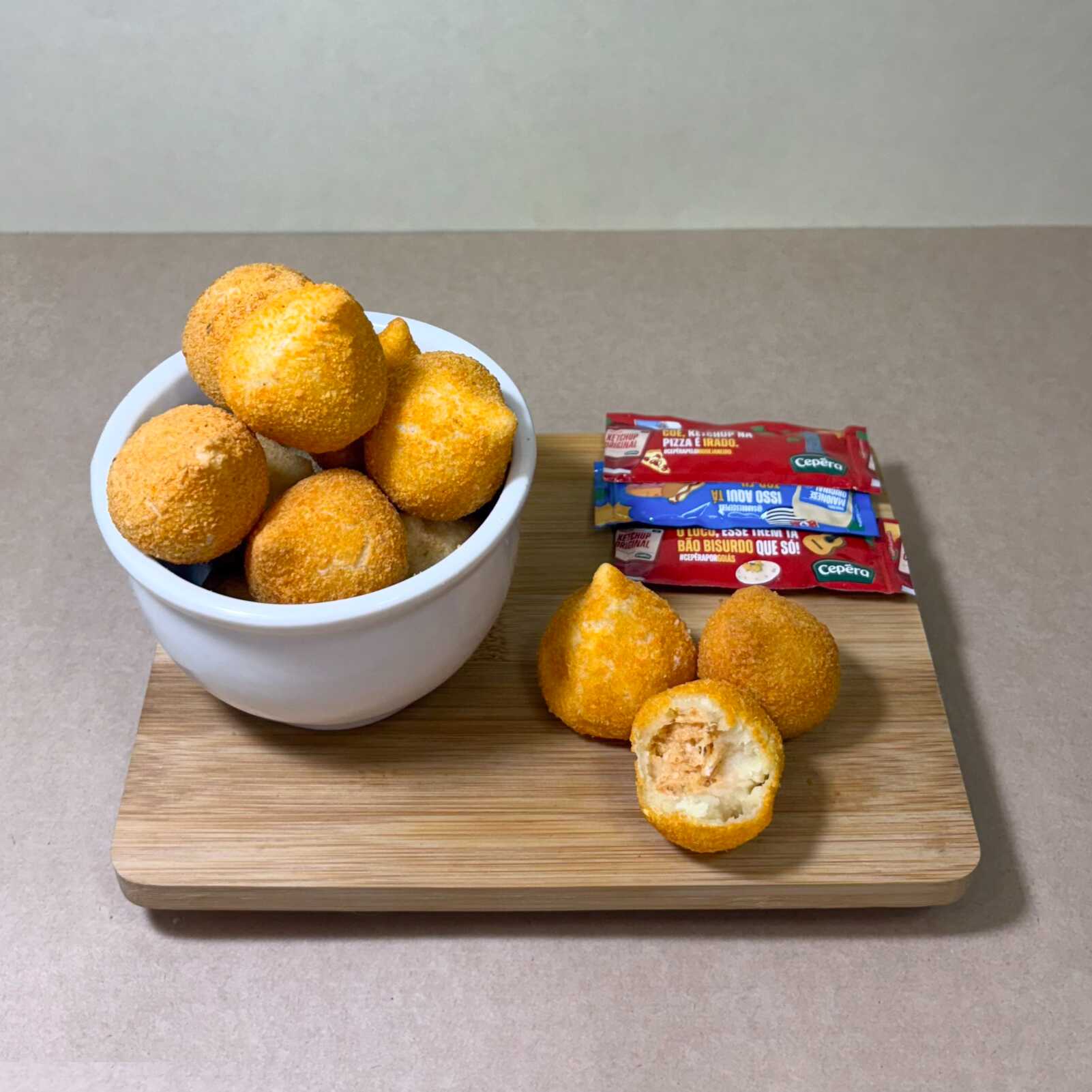 Crocante por fora e com um recheio cremoso e irresistível por dentro! Nossa Coxinha de Frango com Catupiry é feita com massa na medida certa, recheada com frango desfiado temperado e uma generosa camada de Catupiry cremoso que derrete na boca. Frita no ponto perfeito e douradinha, ela é o salgado queridinhos de todos. Perfeita para o lanche ou para aquela hora em que bate uma vontade de algo gostoso!