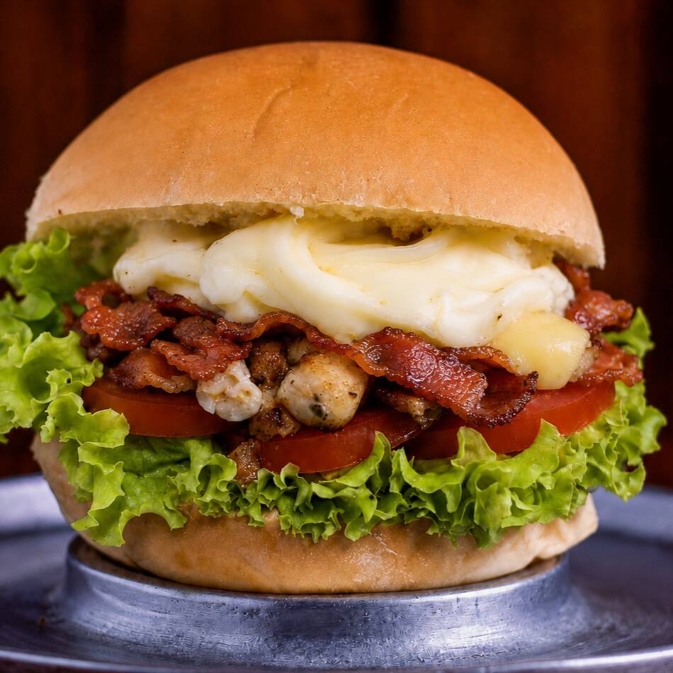 Pão brioche macio com filé de frango suculento, muçarela derretida, requeijão cremoso, bacon crocante, alface, tomate e molho da casa. Cremoso e irresistível.