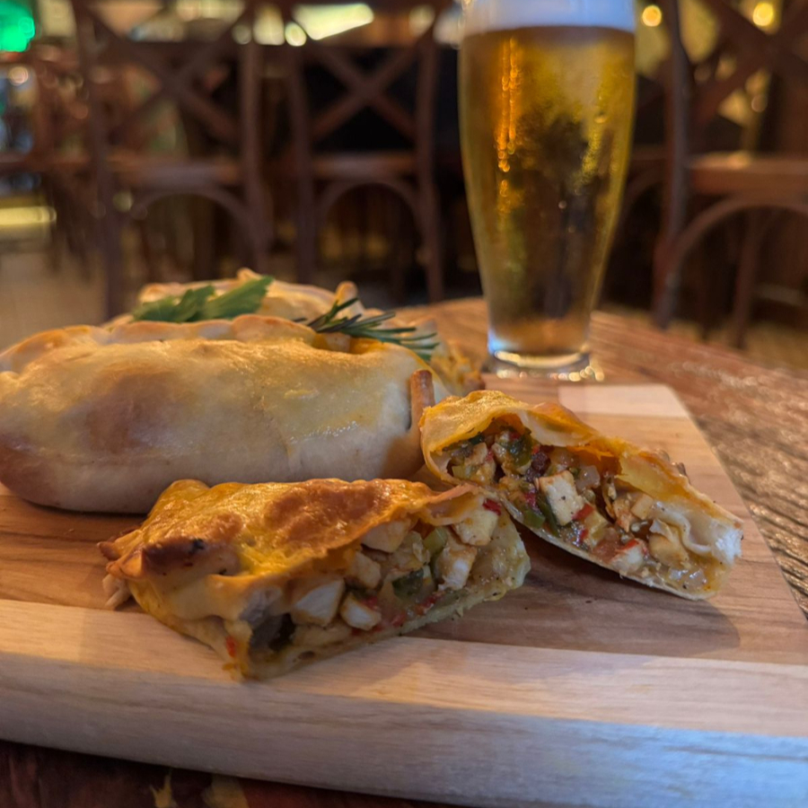 Empanada de frango com um recheio generoso de frango desfiado, refogado com cebola, pimentão e cebolinha fresca.