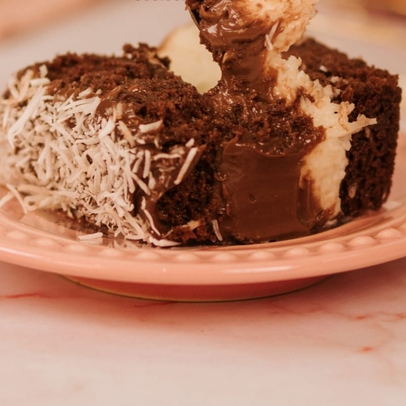 Deliciosa Massa de Chocolate fofinha e molhadinha, muito recheio e cobertura de Brigadeiro e coco cremoso.