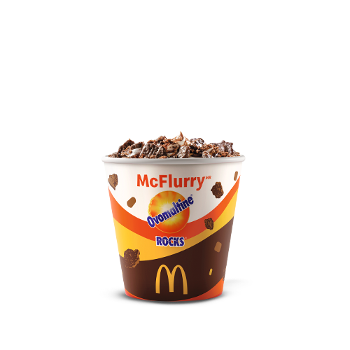 Bebida láctea sabor baunilha, cobertura sabor chocolate, Ovomaltine em pó e pedaços crocantes de Ovomaltine Rocks.