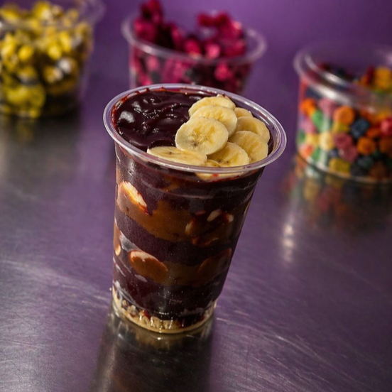 Açai cremoso acompanhado de creme de avelã, amendoin e bananas
