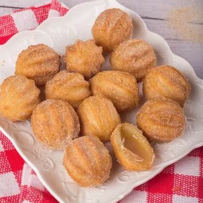 Deliciosos mini churros recheados com o irresistível doce de leite. Crocantes por fora, macios por dentro, uma explosão de sabor a cada mordida. Ideal para compartilhar ou saborear sozinho. Experimente essa tentação dos deuses e deixe-se levar por essa delícia clássica da culinária espanhola. Uma combinação perfeita entre a massa fofinha e o doce de leite cremoso. Não resistir é impossível!