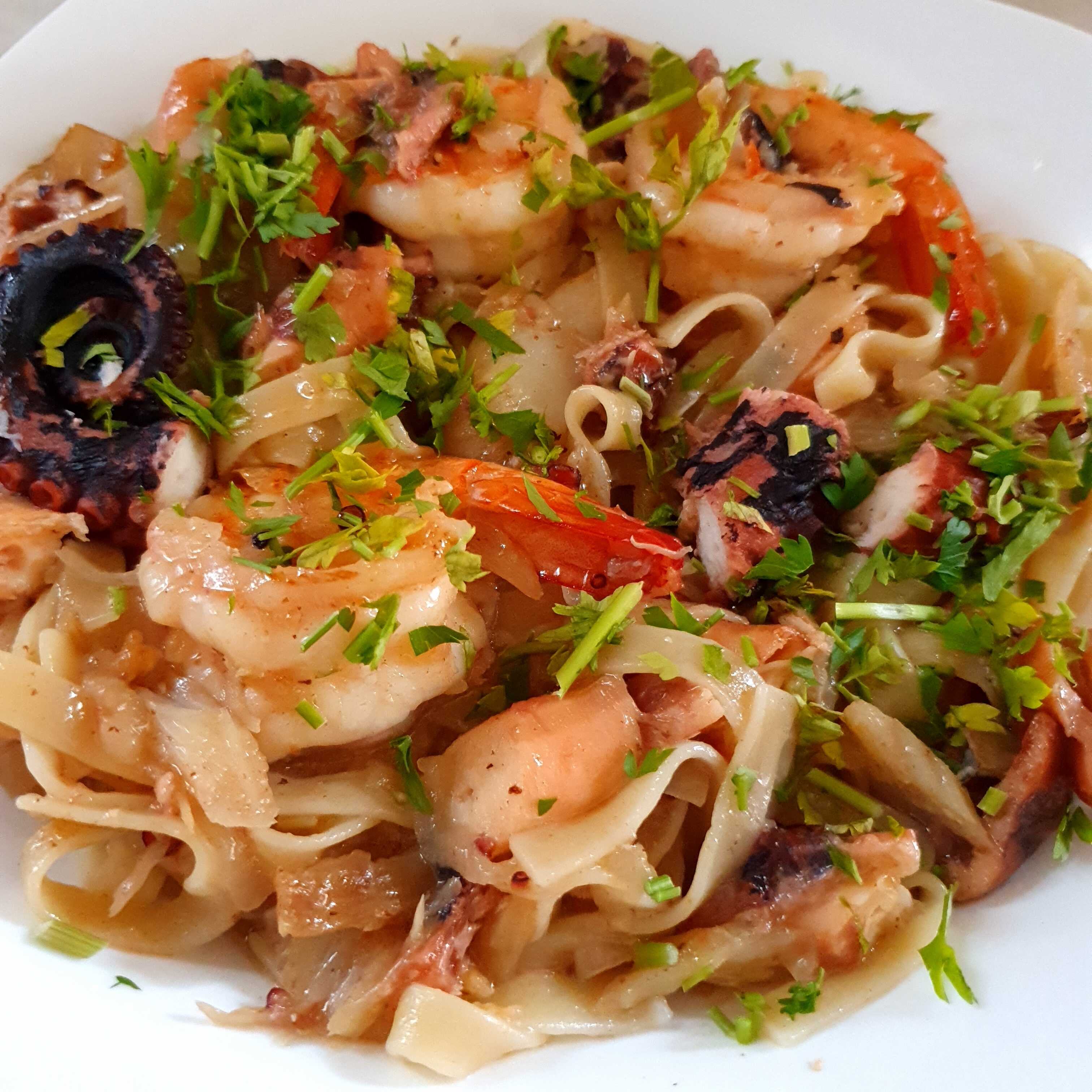 Talharim refogado com cebola, bacalhau e camarão, regados com azeite.