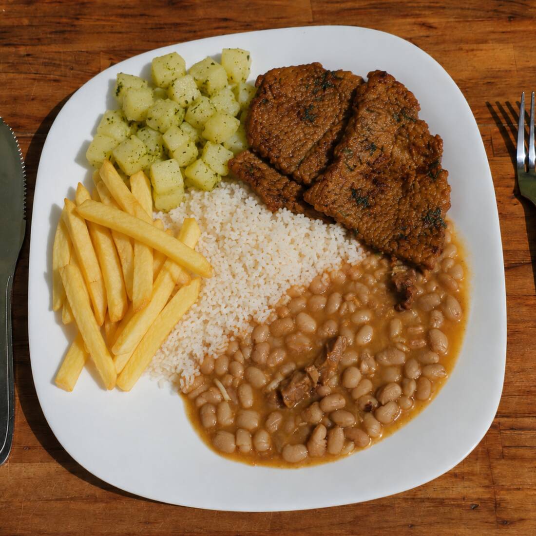 Bife de coxão acebolado com arroz, feijão, legumes e batata frita.