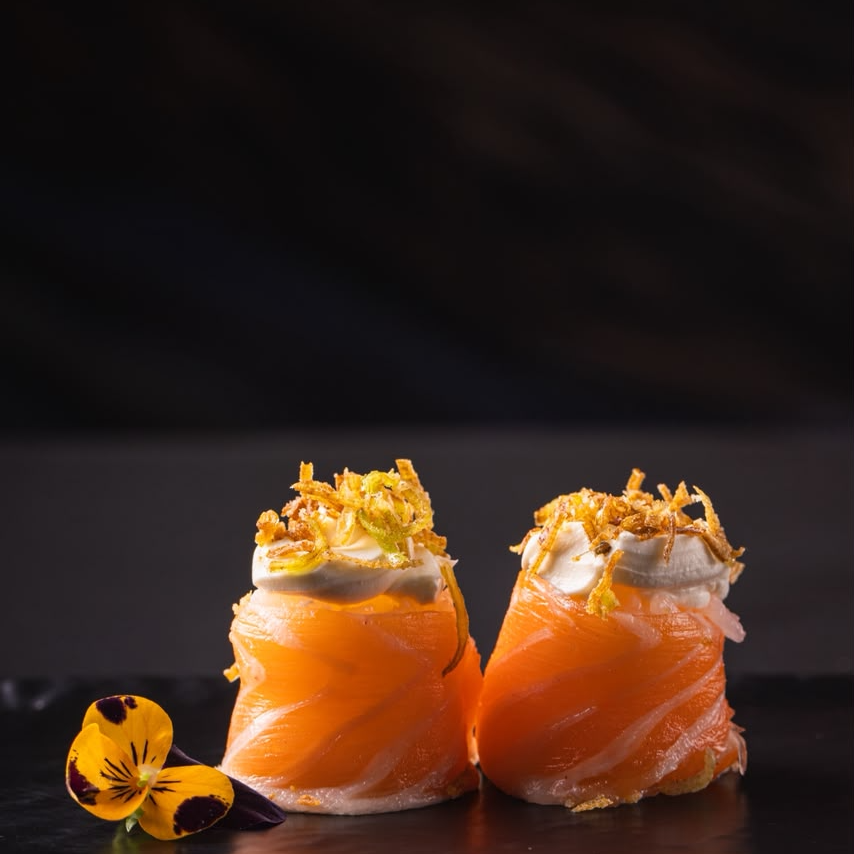 2 peças — Joe Alho-Poró: arroz japonês envolto por fatias de salmão fresco, recheado com cream cheese cremoso e finalizado com alho-poró por cima. Uma explosão de sabor que combina leveza, cremosidade e um toque especial em cada peça! 🍣✨