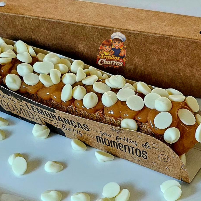 Delicioso churros gourmet salpicado com açúcar de confeiteiro e canela em pó com recheio e cobertura de doce de leite ou doce de chocolate coberto com gotas de chocolate branco.