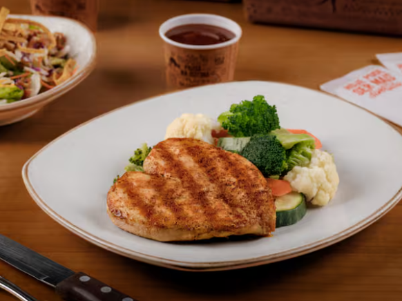 Um suculento peito de frango grelhado em chama aberta, servido com o molho barbecue.