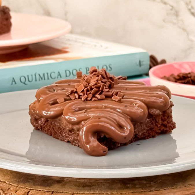 Massa nuvem de chocolate, fofinha e aerada, embebida numa calda especial de cacau e coberta com brigadeiro de panela