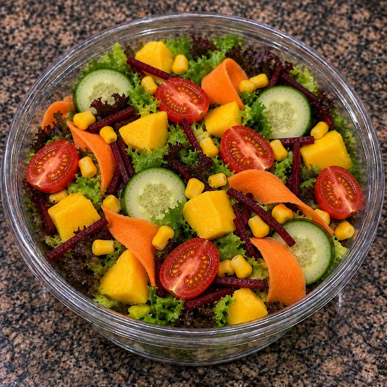 Uma combinação leve, crocante e refrescante de folhas, tomate-cereja, cenoura, pepino, beterraba, milho e manga.