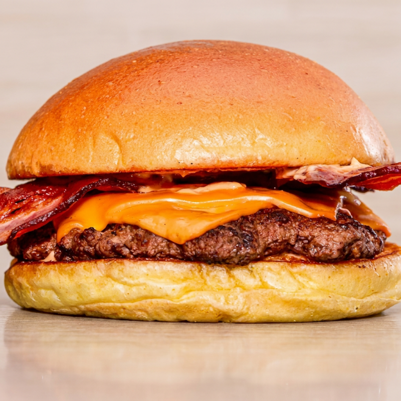 Delicioso Hambúrguer Artesanal. Pão Selado, Smash de 80g, Tiras de Bacon Crocante, Queijo Cheddar, Molho Barbecue, Maionese