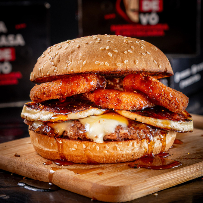 Pão Gourmet, smash burguer 100g, quaijo mussarela, queijo coalho, anéis de cebola empanado, cebola na chapa e mel de engenho.