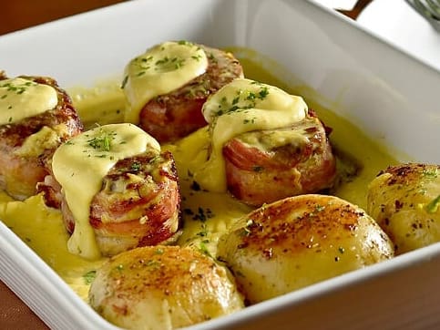 Medalhões de filé mignon com bacon, grelhados, flambados com conhaque e molho de mostarda. Acompanha arroz branco e batata ao murro.