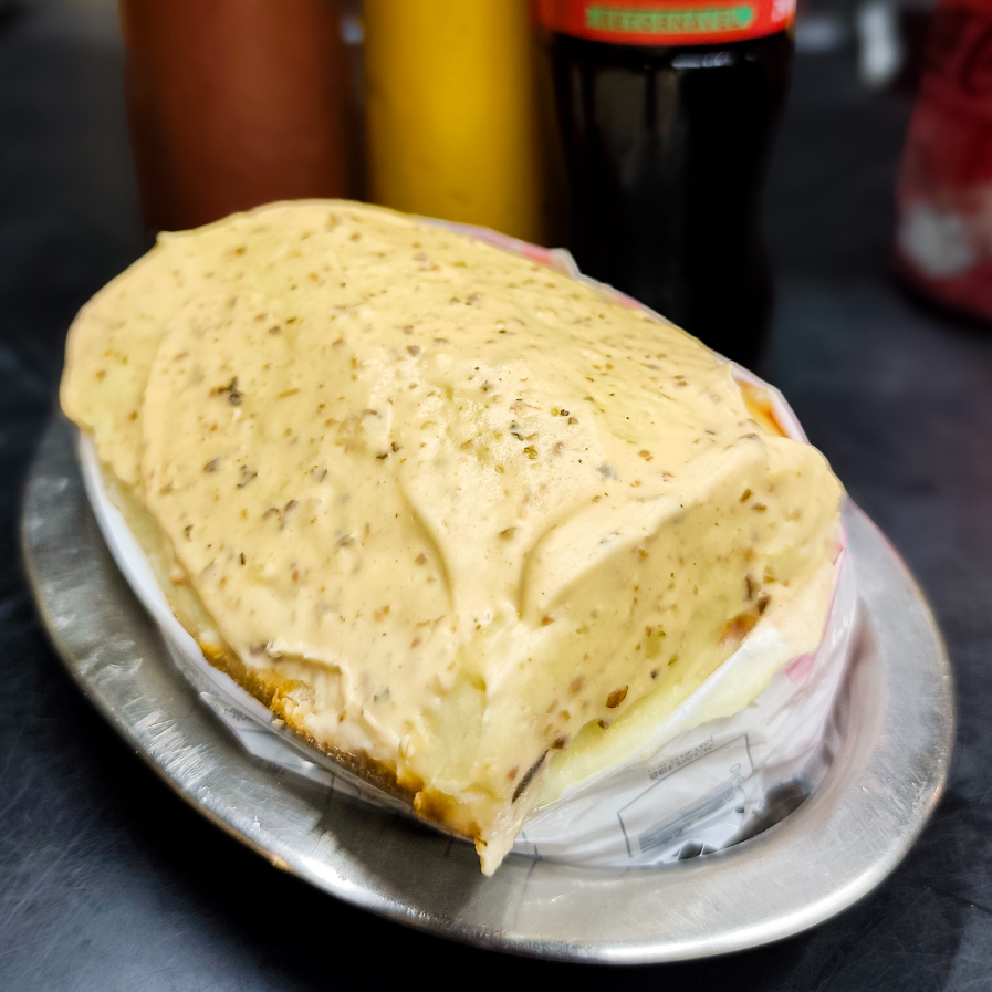 Pão, salsicha, ketchup e mostarda, vinagrete sem cebolas, O melhor pure de batatas da vida e finaliza com maionese hellmans temperada com patê de azeitonas pretas.