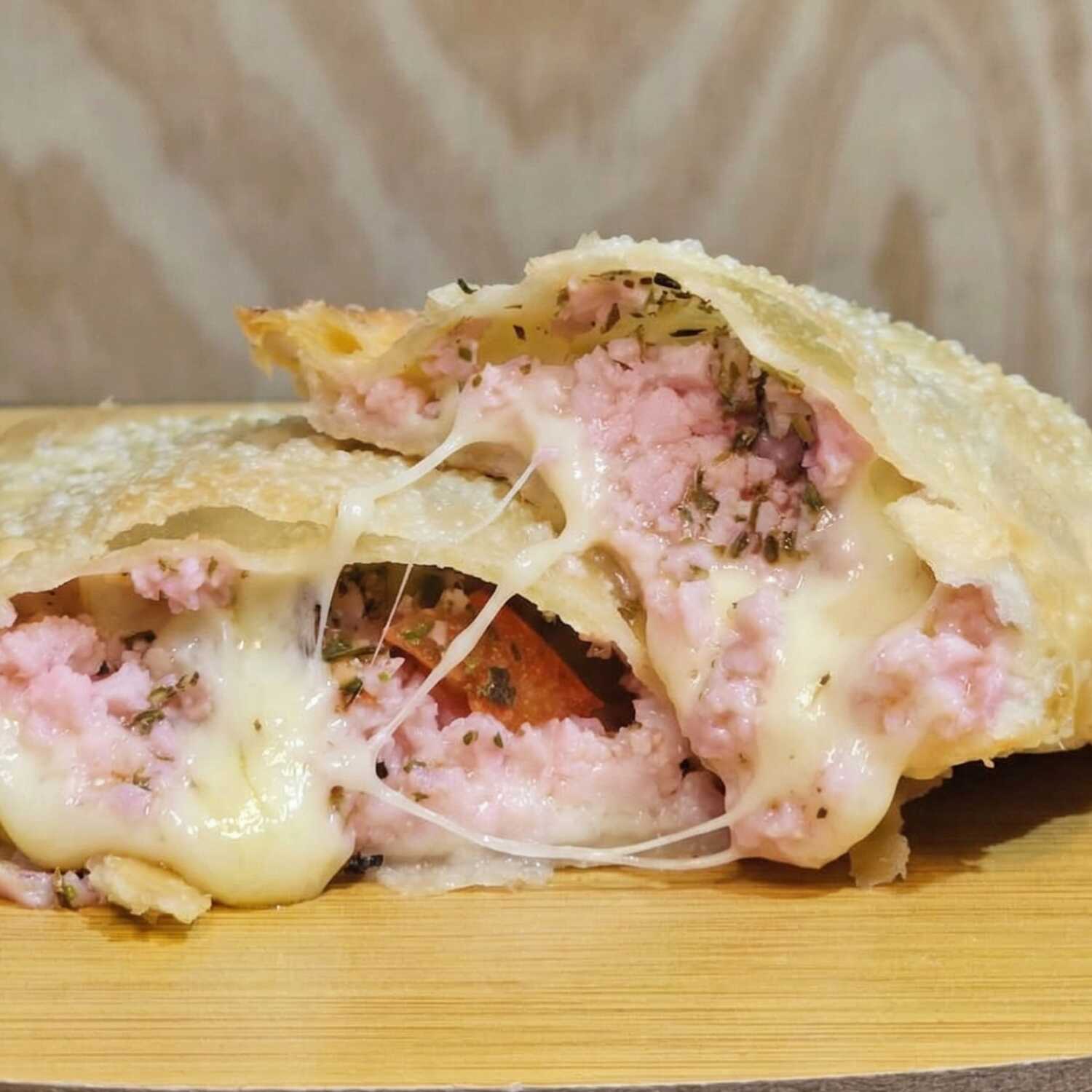 Delicioso pastel recheado com queijo derretido, presunto, tomate e orégano. Um irresistível sabor de pizza! Experimente essa explosão de sabores!