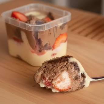Creme moça, morangos picados, geleia artesanal de morango, mousse de chocolate meio amargo, brownie e raspas de chocolate ao leite.