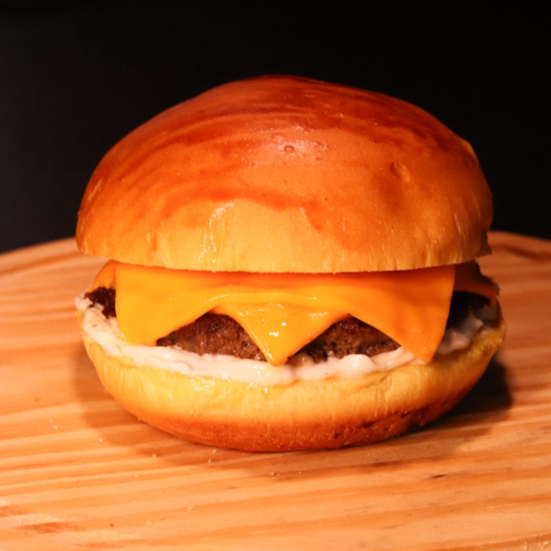 Hambúrguer Smash 100g Suculento com Cheddar Cremoso e Molho Especial da Casa. Um Clássico, Recheado de Sabor.
