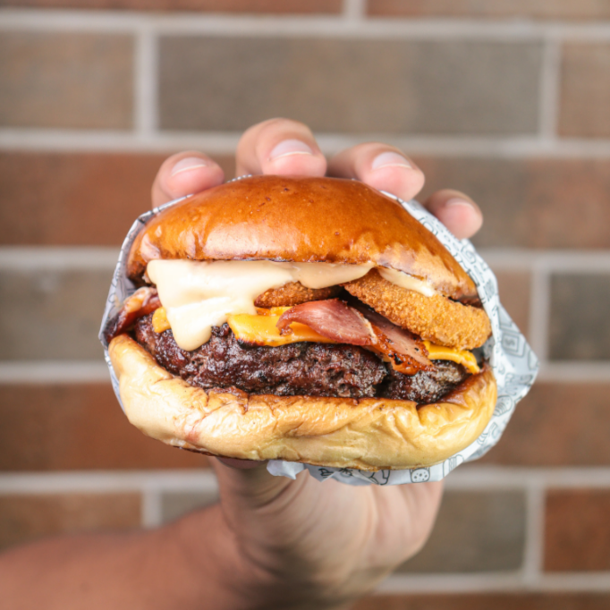 Pão brioche selado na manteiga, com um suculento blend bovino de 180g, queijo cheddar, 3 anéis de cebola, bacon, molho barbecue e molho da casa.