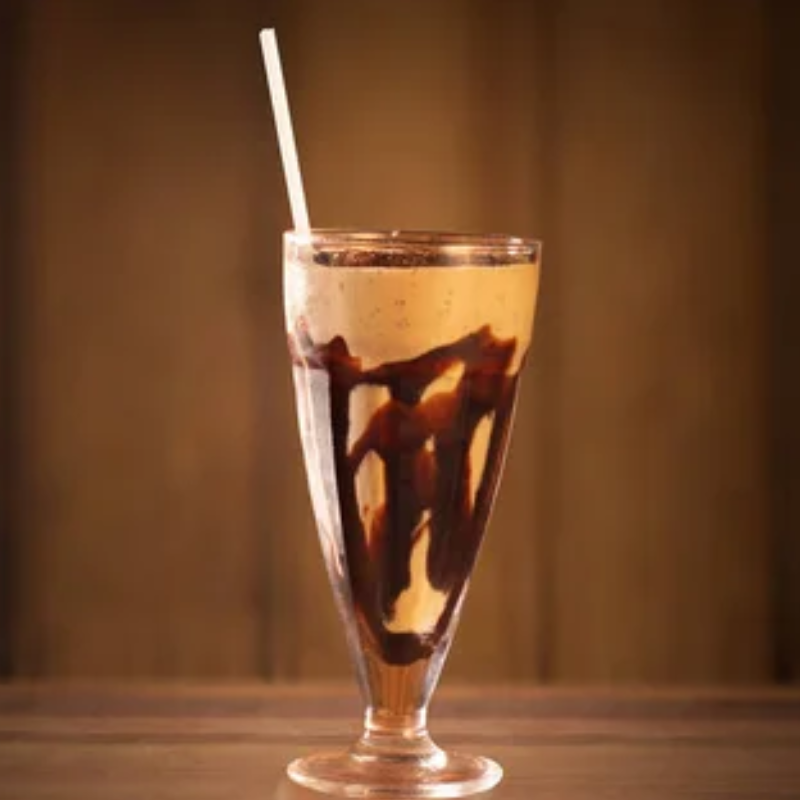 Milkshake Paçoca com Borda de Doce de Leite com Paçoca, Calda de Caramelo, Finalizado com Mais Paçoca para um Sabor Clássico e Irresistível.