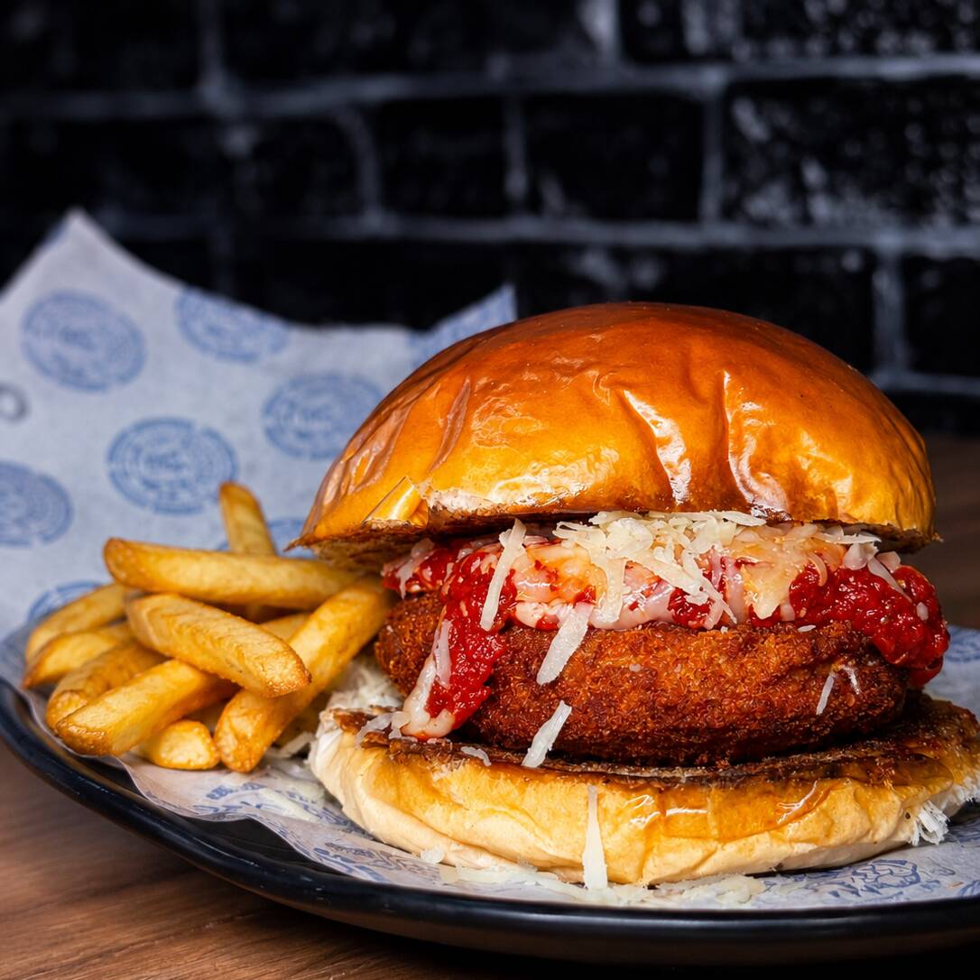 frango empanado crocante, molho de tomate encorpado, muito queijo gratinado e batata frita. Uma releitura de um dos pratos mais amados do Brasil em formato de burger.
Disponível por tempo limitado. 🔥🧀🍔