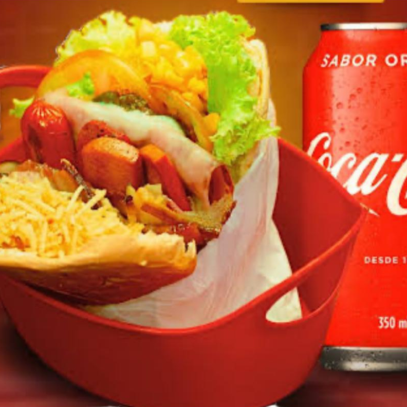 Um X-Tudo completo com muçarela, salsicha, bacon, ovo, alface, tomate, batata palha e milho, acompanhado de refri lata 350ml. O combo perfeito para matar a fome!