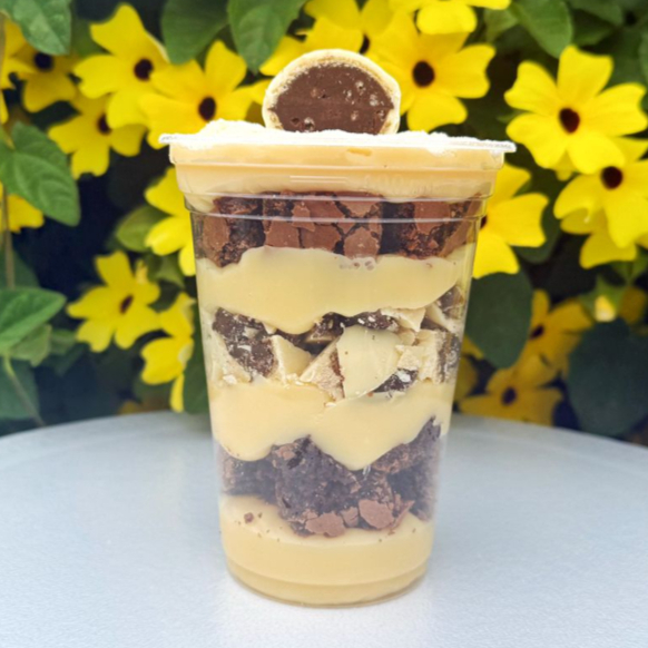 O Copo da Felicidade de Ouro Branco é puro luxo em forma de sobremesa! Recheado com pedaços generosos do famoso bombom, ele se mistura a camadas cremosas de creme de Ninho e Brownie, criando uma combinação irresistível entre o sabor marcante do chocolate branco, o recheio suave de chocolate ao leite e a cremosidade do leite em pó. Cada colherada é uma explosão de sabor que derrete na boca e conquista de primeira!