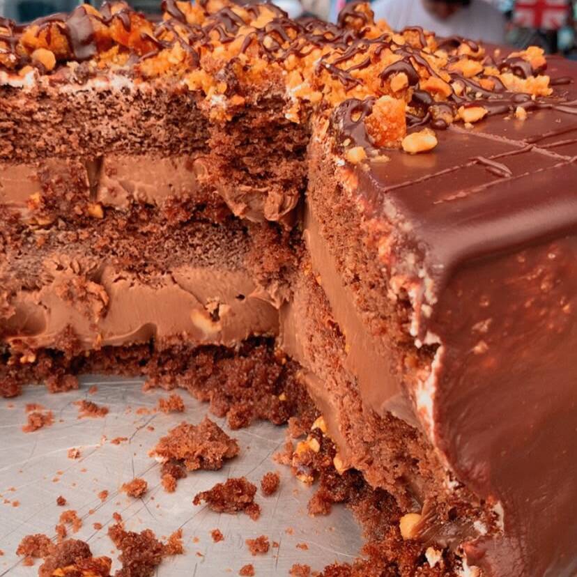 Uma Fatia Generosa , Preparada Com Massa De Chocolate Super Fofinha, Recheio Cremoso De Chocolate, Pedaços De Crocante De Amendoim E Cobertura De Ganache De Chocolate.