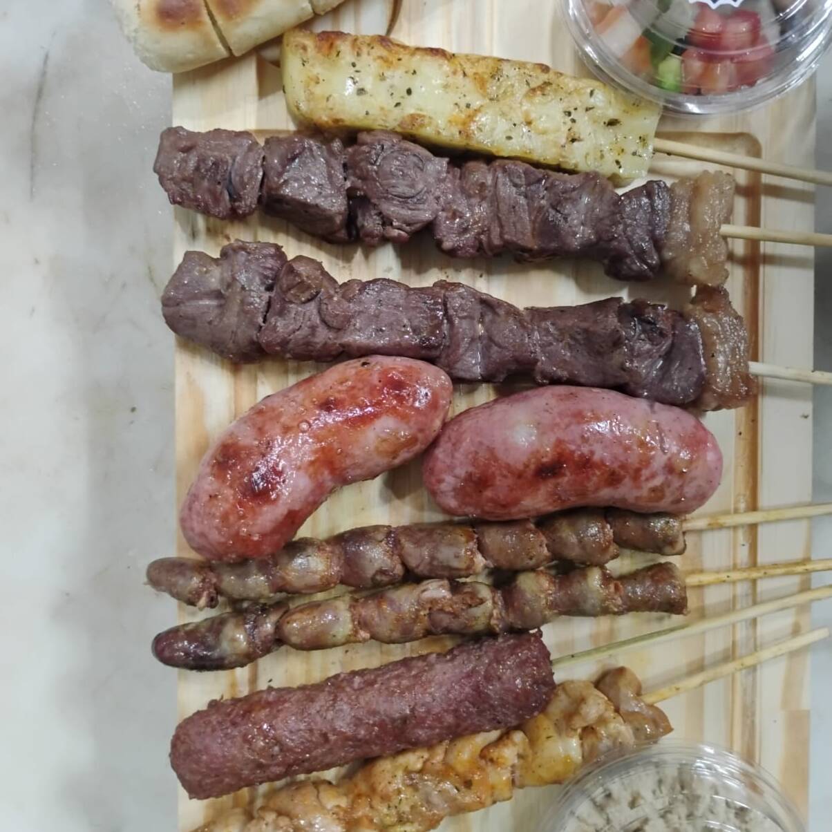 02 Espetos de Carne + 02 Espetos de Coração + 02 Espetos de Linguiça + 01 Espeto de Queijo Coalho + 01 Espeto de Filé da Coxa ( Frango ) + 01 Espeto de Kafta + 01 Pão de Alho + 01 Farofa Pequena + 01 Vinagrete Carioca Pequena.