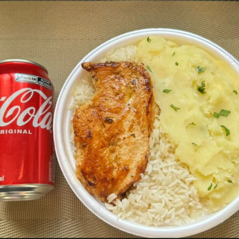 Marmita com delicioso filé de frango grelhado acompanhado de arroz branco, feijão e purê de batata. Acompanha refrigerante lata Coca Cola 350ml. Marmita indicada para 01 pessoa.
