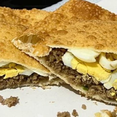 massa crocante sequinha, 15cm, recheda com carne moída temperada, pedaços de ovo cozido.