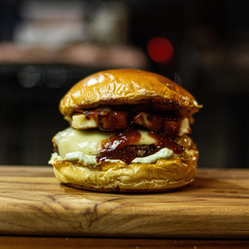Pão brioche selado na brasa, blend 120g super suculento, bacon crocante, muçarela fatiada, queijo coalho na brasa, geleia de goiabada e maionese da casa.