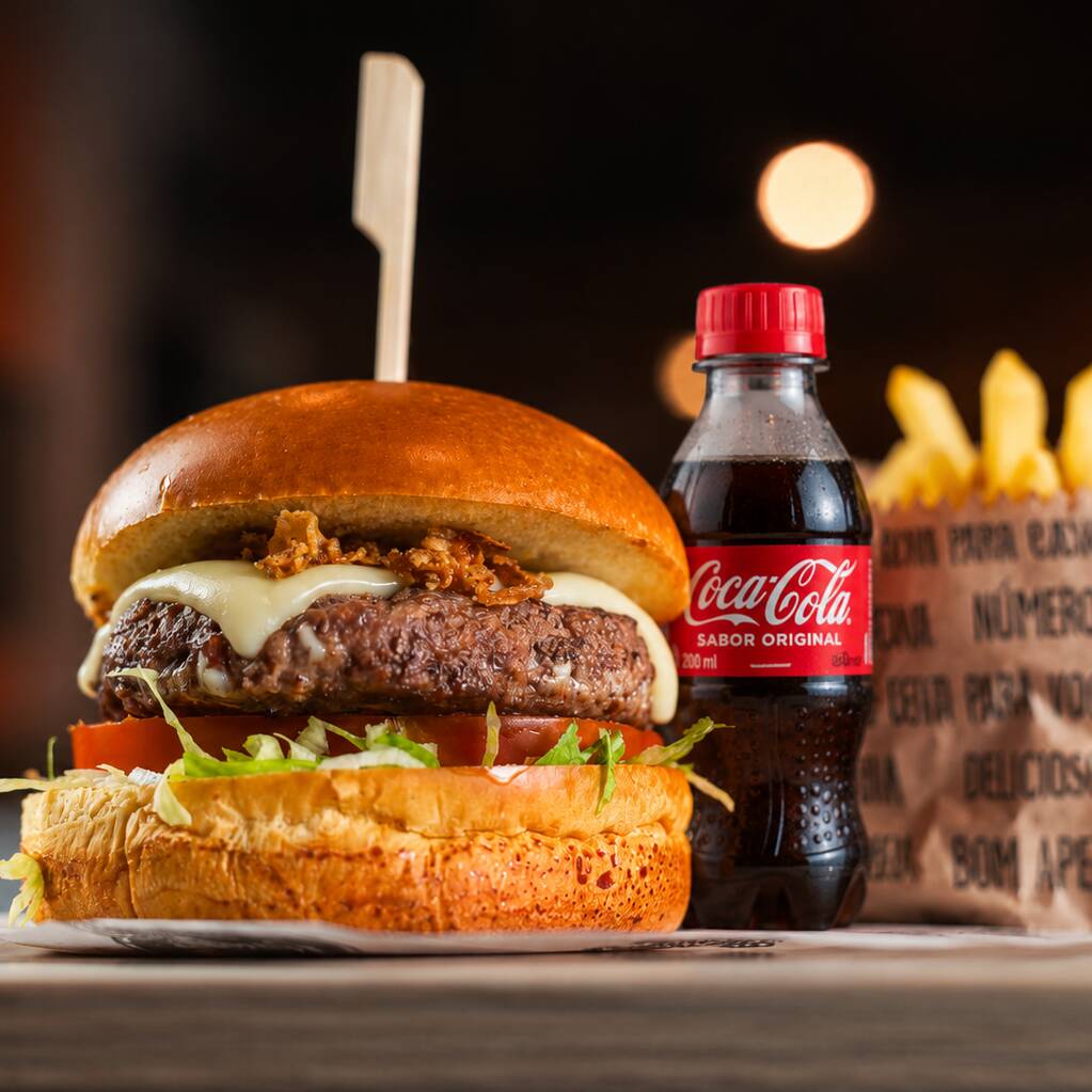 No pão brioche macio, um hambúrguer artesanal de 140g, queijo mussarela derretido, alface fresca, tomate, e nossa maionese especial da casa. Acompanha batatas fritas crocantes e um refrigerante Coca pet 200ml. Uma escolha clássica e cheia de sabor!