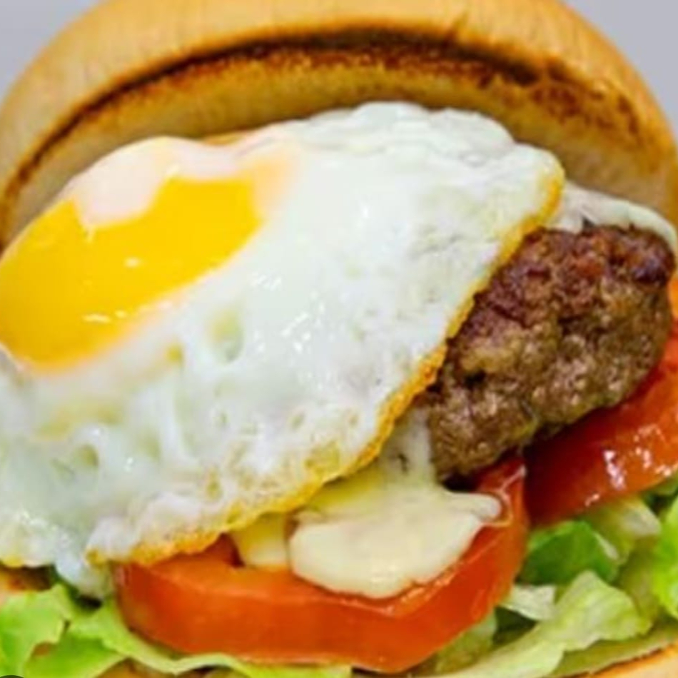 Pão de hambúrguer, ovo, hambúrguer artesanal de 150 gramas, queijo, presunto, milho, ervilha, tomate, alface e maionese caseira