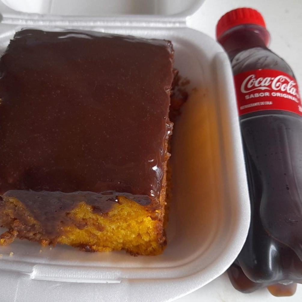 Bolo de cenoura fofinho com cobertura de chocolate, um clássico que agrada a todos. + 1 mini coca-cola pet de 200 ml geladinha