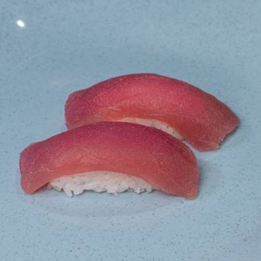 Lâmina de salmão sobre porção de arroz.