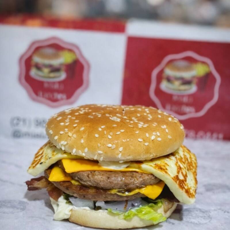 Pão , 2 carnes , queijo coalho , queijo cheddar , bacon , picles , cebola roxa e salada .