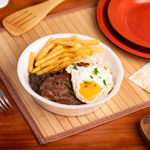 Bife de alcatra, ovo frito, arroz branco soltinho, feijão preto com caldo, acompanhados por batatas fritas.