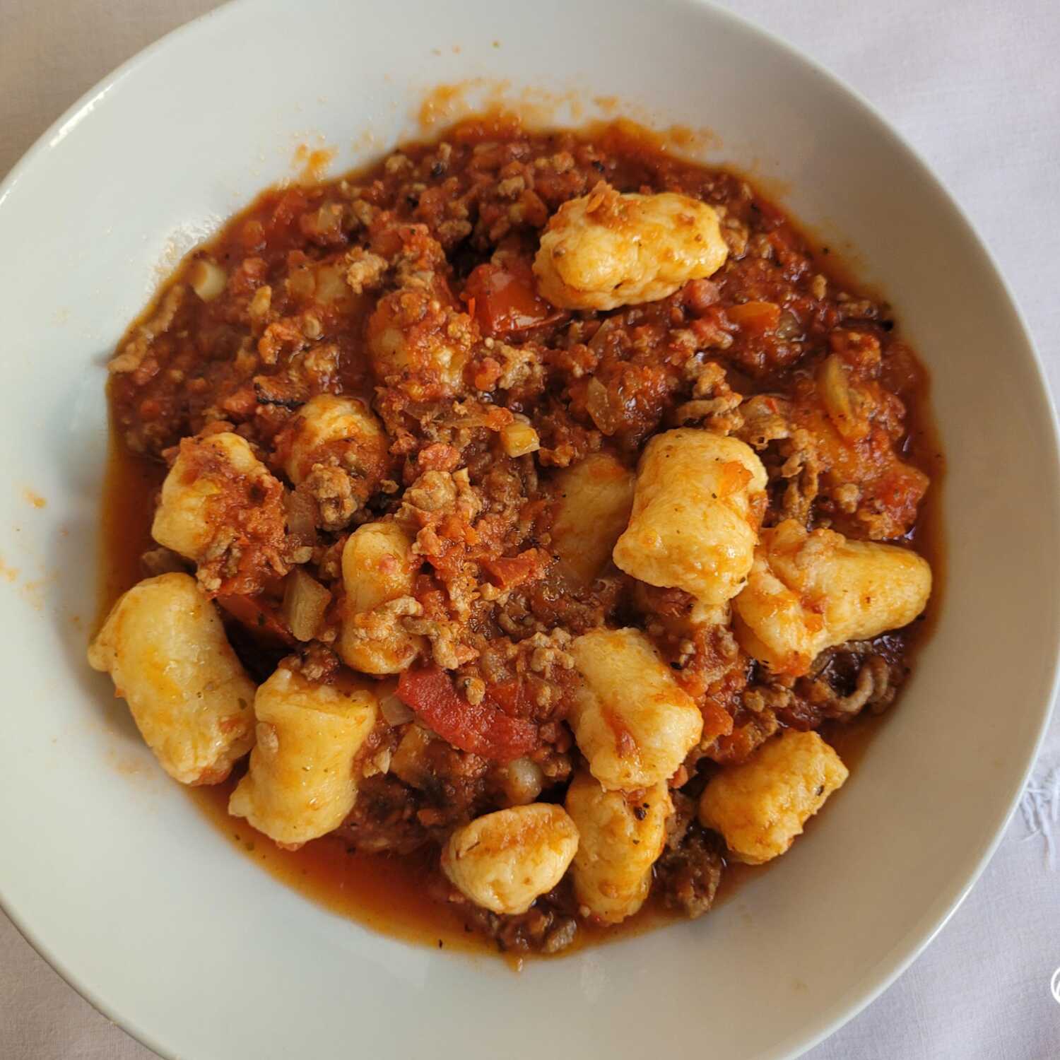150g de um delicioso nhoque, acompanha arroz e carne moída e queijo ralado por cima