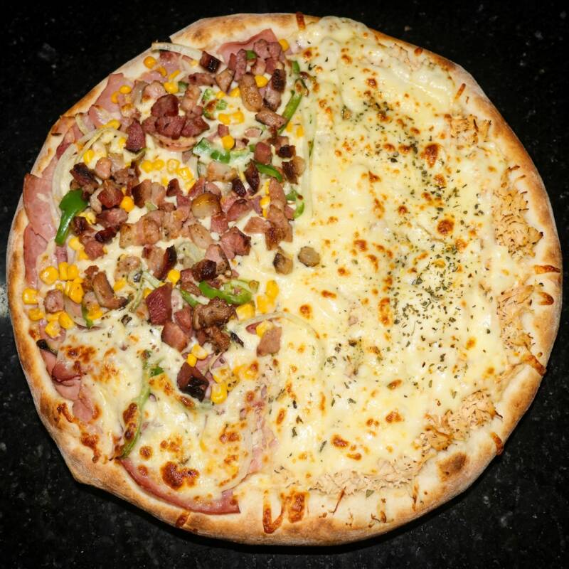 A combinação preferida dos nossos clientes. Os dois sabores mais vendidos, que conquista o paladar de qualquer apaixonado por pizza. Sabor á moda com mussarela, presunto, calabresa, bacon, cebola, pimentão, milho e orégano. Sabor Frango com Catupiry com mussarela, frango, Catupiry e orégano.